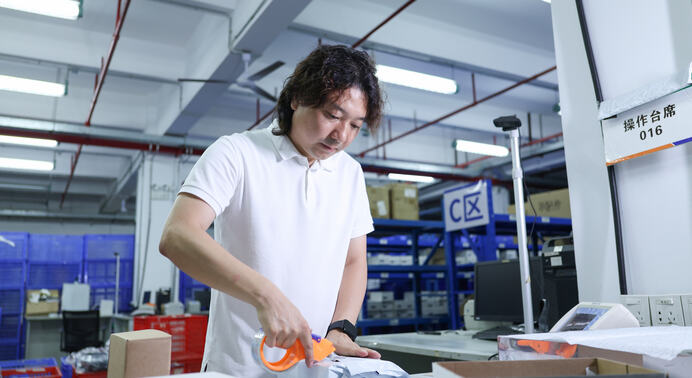 Janson Wang on the ASG warehouse floor reviewing tracking events across multiple carriers and warehouses