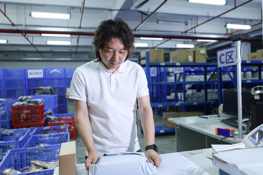 Janson reviewing a parcel at an ASG warehouse packing station