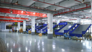 A wide ASG warehouse floor with blue parcel conveyors and clear marked aisles.