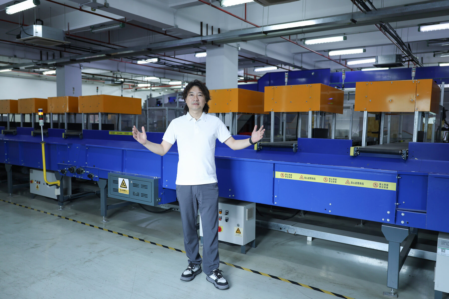 ASG parcel scanning line with a conveyor, monitor, warehouse worker, and sorting equipment on the fulfillment floor.