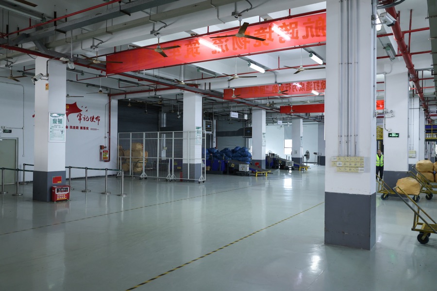 An open warehouse floor beside parcel handling equipment