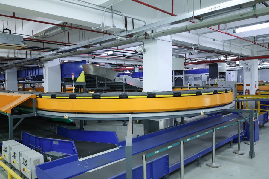 Curved sorting conveyor and blue conveyor belts in a warehouse
