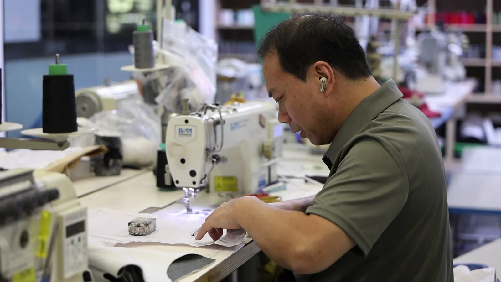 Operator at a sewing station on the production line