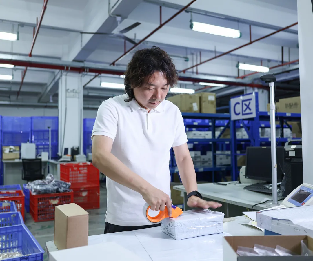 Janson Wang taping a packed order at an ASG packing station