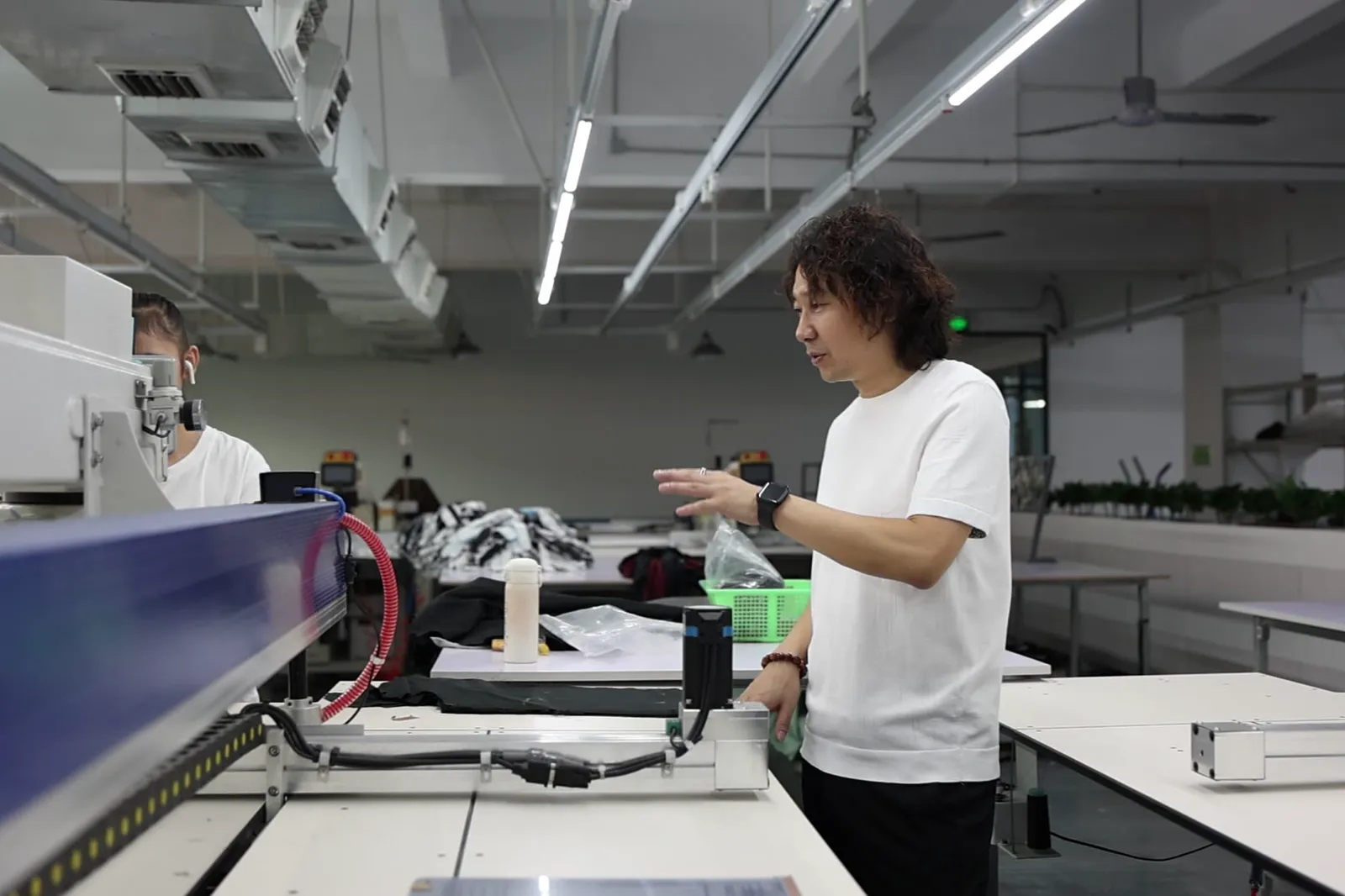 Founder Janson Wang reviewing work at a factory cutting table
