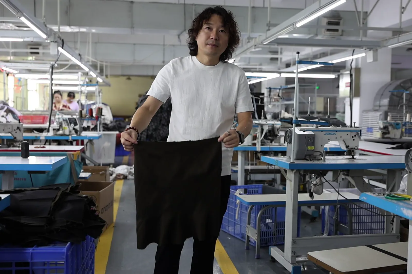 Founder Janson Wang reviewing a finished garment on a factory floor