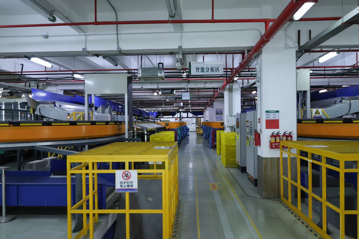 Yellow roll cages lined up along a warehouse aisle