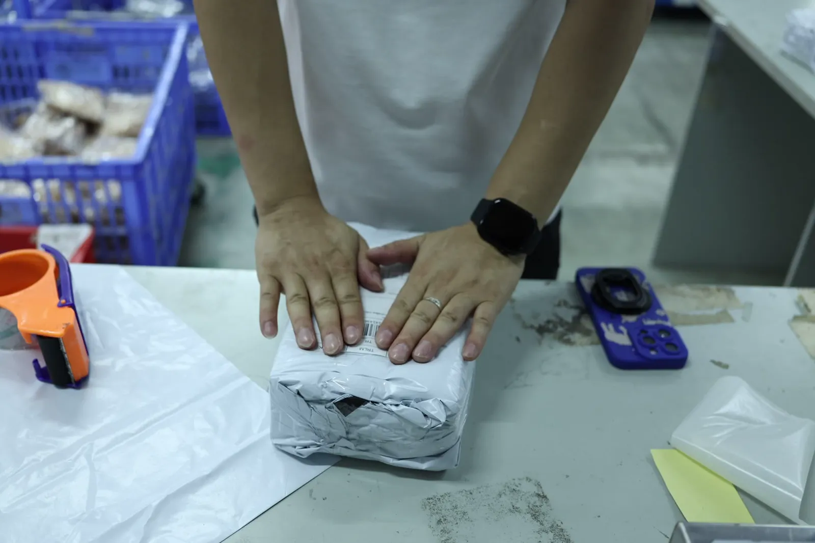 Hands packing an order at an ASG packing station